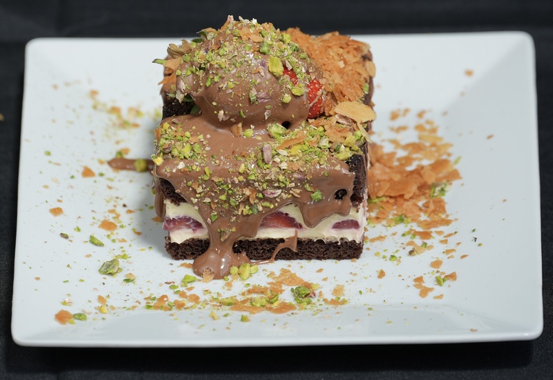 Devil's cake, milk cream, strawberries, Belgian chocolate, Antep pistachio, and crêpe crumbs